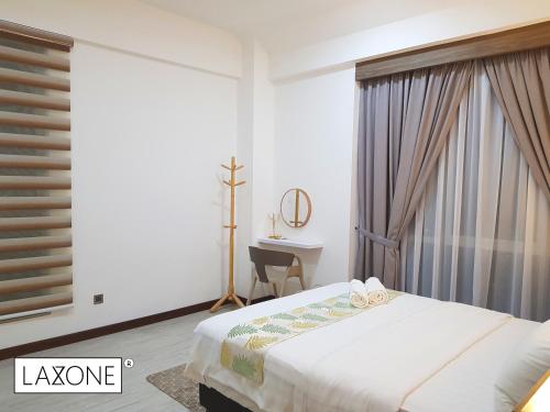 a bedroom with a bed and a desk and a window at Sutera Avenue Kota Kinabalu - Laxzone Suite in Sembulan