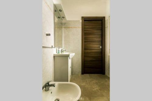 ein Badezimmer mit einem Waschbecken, einem WC und einem Spiegel in der Unterkunft Accogliente Bussana 2 in Sanremo