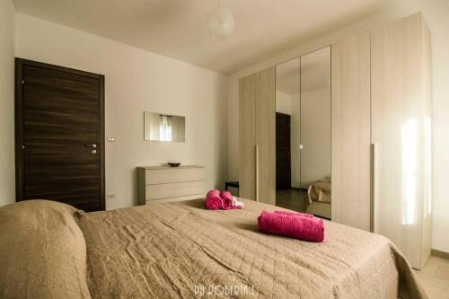 ein Schlafzimmer mit einem rosa ausgestopften Tier auf einem Bett in der Unterkunft Accogliente Bussana 2 in Sanremo
