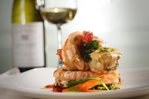 a plate of shrimp with a bottle of wine at Erbil Rotana in Erbil