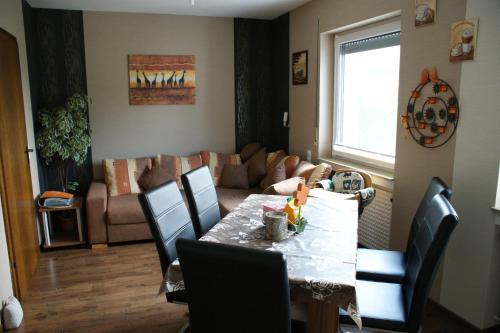 een woonkamer met een tafel en een bank bij Ferienwohnung Lippert in Künzell