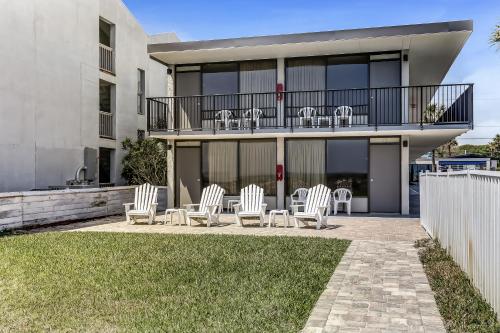 a patio with chairs and tables on a building at Beachside Motel - Amelia Island in Amelia Island
