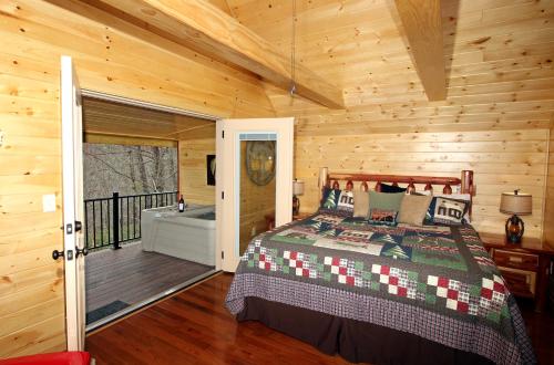 a bedroom with a bed and a balcony with a tub at Lovin' Inn in Gatlinburg