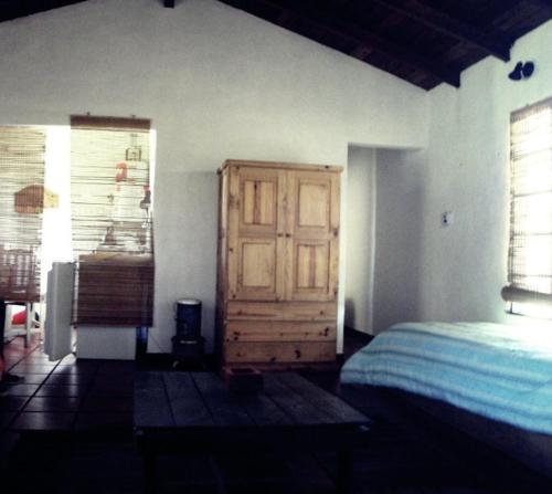 1 dormitorio con 1 cama y puerta de madera en CABAÑAS TRUDY TANDIL en Tandil
