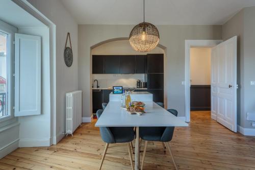a kitchen with a table and chairs in a room at IMPERIAL Apartment in the center of Biarritz close to the beach in Biarritz