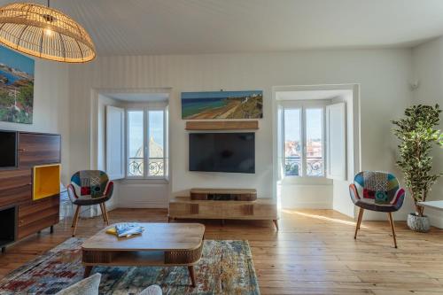 a living room with a tv and a table and chairs at IMPERIAL Apartment in the center of Biarritz close to the beach in Biarritz