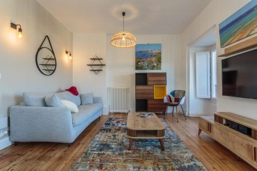 un salon avec un canapé bleu et une table dans l'établissement IMPERIAL Apartment in the center of Biarritz close to the beach, à Biarritz