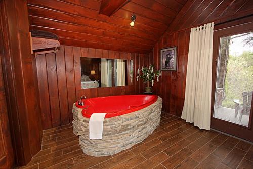 een badkamer met een groot rood bad in een kamer bij Burnin' Love in Gatlinburg