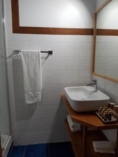 a bathroom with a sink and a shower with a mirror at Posada Condado de la Mota in Mogro