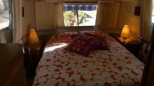 a bedroom with a bed and two lamps and a window at Belrepayre Airstream Camp in Manses