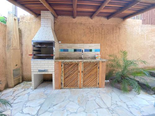 a outdoor kitchen with a grill and a counter at Casa das Embaúbas in Ilhabela