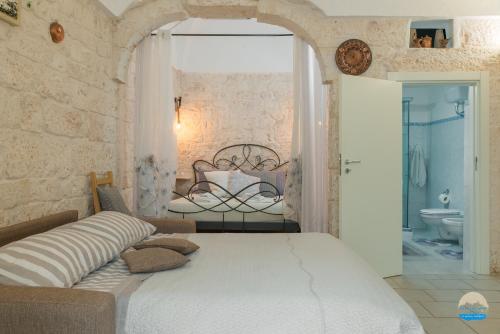 a bedroom with a large bed and a bathroom at Casa Francesca in Ostuni