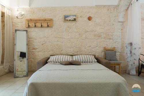 a bedroom with a large bed with a mirror at Casa Francesca in Ostuni