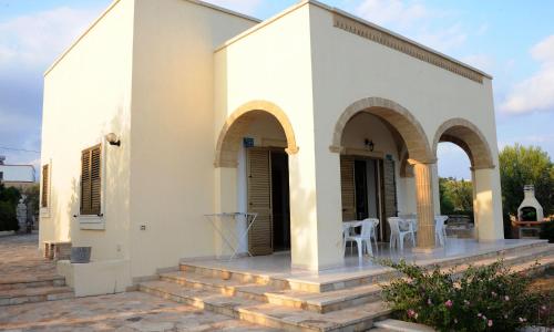 ein kleines weißes Gebäude mit zwei Bögen und einer Terrasse in der Unterkunft Villa Carol in Torre Vado