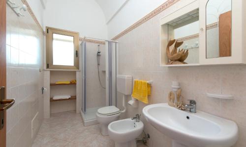 een badkamer met een wastafel, een toilet en een douche bij Villa Carol in Torre Vado