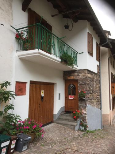 a building with a balcony and a door and flowers at Casa Sicina in Sicina