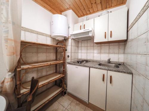una pequeña cocina con armarios blancos y fregadero en Apartments Vintijan, en Pula