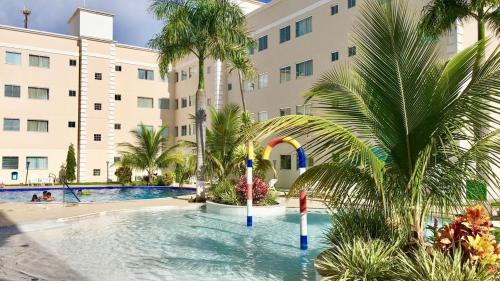 a swimming pool in front of a building with palm trees at Resort Encontro das Águas in Caldas Novas