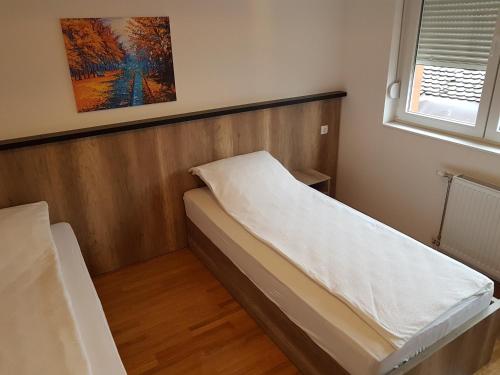 a small room with a bed and a window at Apartmani Simić Quatro in Valjevo