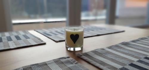 a glass of coffee sitting on a table with three mats at Penthouse apartmán Minerál B-4 in Bardejovské Kúpele