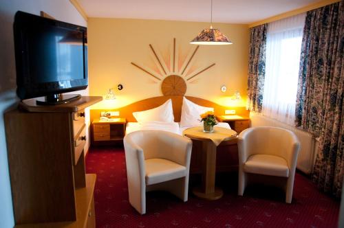 a hotel room with a bed and a television at Pension Gertraud in Bad Kleinkirchheim