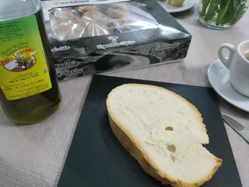 
a sandwich on a table next to a bottle of wine at HOTEL RURAL SIERRA DE FRANCIA in Sotoserrano
