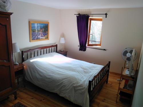 - une chambre avec un grand lit et une fenêtre dans l'établissement Gites La Chabanaise, à Beaulieu-sur-Dordogne