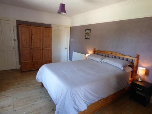 a bedroom with a large white bed with two lamps at St Clair House in Orkney