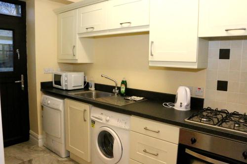 a kitchen with a sink and a washing machine at Emy Lake Apartment - near Castle Leslie, Glaslough in Monaghan
