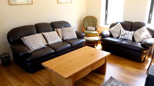 a living room with a leather couch and a coffee table at Emy Lake Apartment - near Castle Leslie, Glaslough in Monaghan