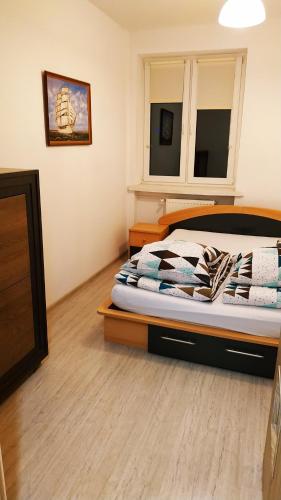 1 dormitorio con 1 cama y suelo de madera en Gdańska 5, en Słupsk