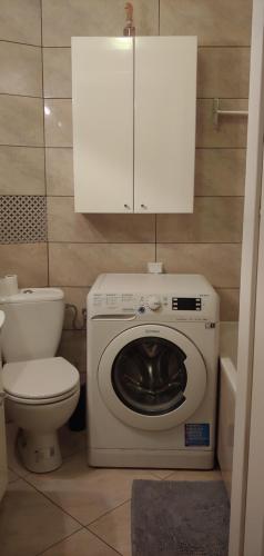 een badkamer met een wasmachine en een toilet bij Barbara in Kalisz