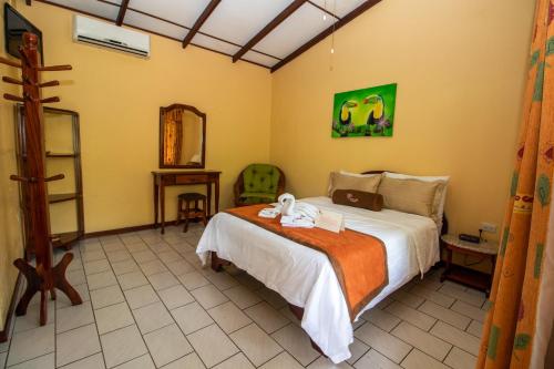 a bedroom with a bed and a mirror at Hotel La Rosa de America in Alajuela City
