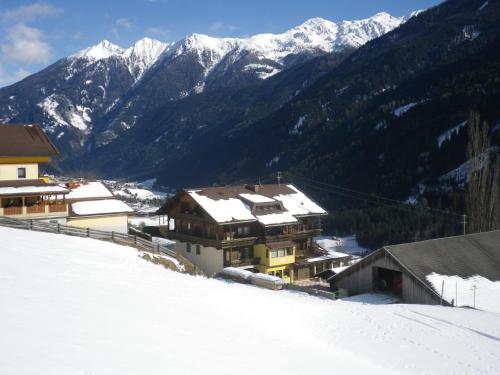 a group of buildings in the snow with mountains at Pension Pichlerhof in Stall