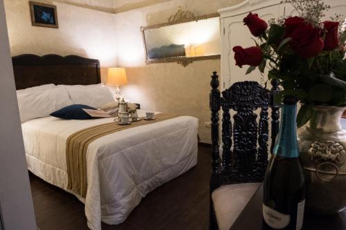 a bedroom with a bed with a vase of roses at Casa Falleri Boutique Hotel in Lima