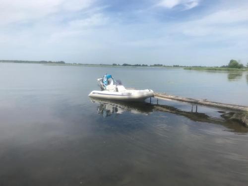 a small white boat on a body of water at Villa Ievynė in Paežeriai