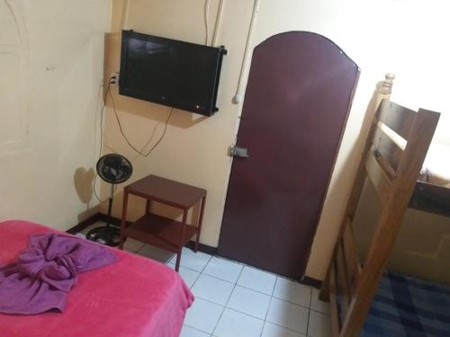 1 dormitorio con 1 cama y TV de pantalla plana en Hotel Coto, en San José