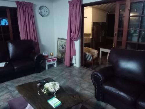 a living room with two leather chairs and a table at Stesh Margate Holiday House 12 Sleeper in Margate