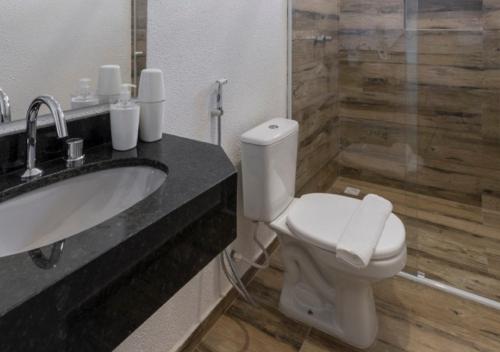 a bathroom with a toilet and a sink and a shower at Pousada Castellammare in Bombinhas