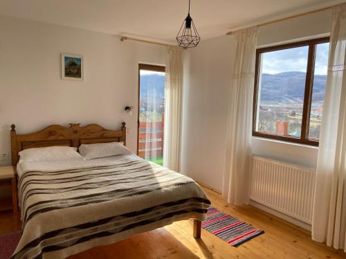 a bedroom with a bed and a large window at Poème in Sighetu Marmaţiei