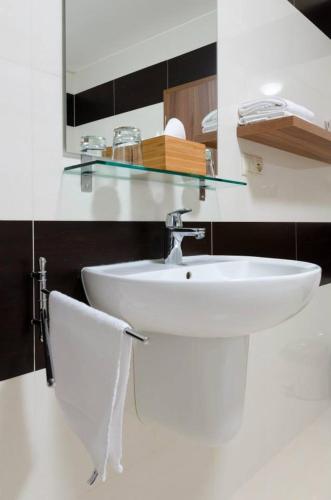 a bathroom with a white sink and a mirror at Penzion Lipa in Cífer