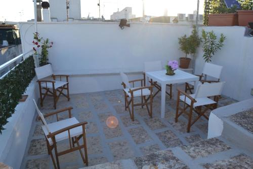 a patio with tables and chairs on a white wall at Casa Filomena in Ostuni