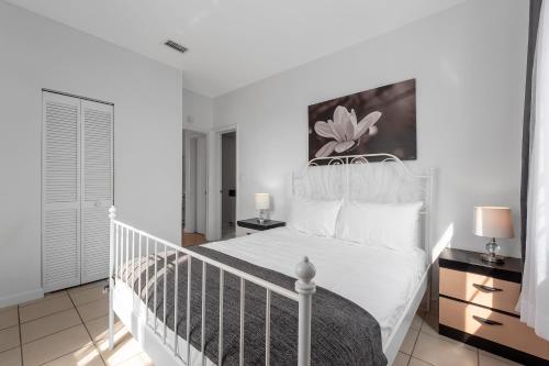 1 dormitorio con 1 cama blanca con marco de cama blanco en South Beach Two Bedroom Apartment, en Miami Beach