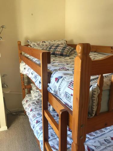 a bedroom with a bunk bed with a wooden frame at Aelfor Cozy Cottage in Barmouth
