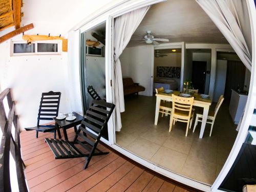 a room with a table and chairs on a deck at Caribe Dream Private Beach in Mahahual