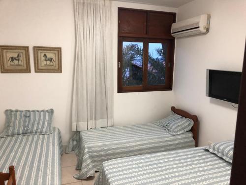 two twin beds in a room with a window at Flat 4 Suites Hotel Portal Gravata in Gravatá