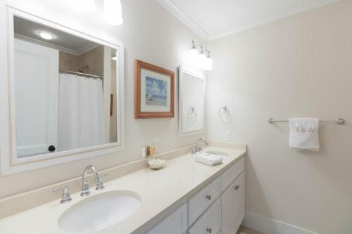 La salle de bains blanche est pourvue d'un lavabo et d'un miroir. dans l'établissement Sea Bluff Townhomes 02, à Santa Rosa Beach