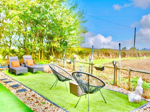 a yard with two chairs and chairs on the grass at Sunset log cabin in Sudbury