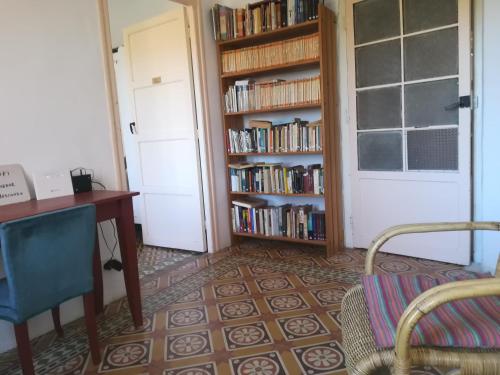 Cette chambre comprend un bureau et une étagère avec des livres. dans l'établissement Albergue el Hacedor, à La Aldea del Portillo de Busto