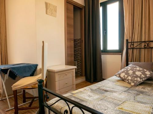 um quarto com uma cama, uma cadeira e uma janela em le Rose di santina em Mamoiada